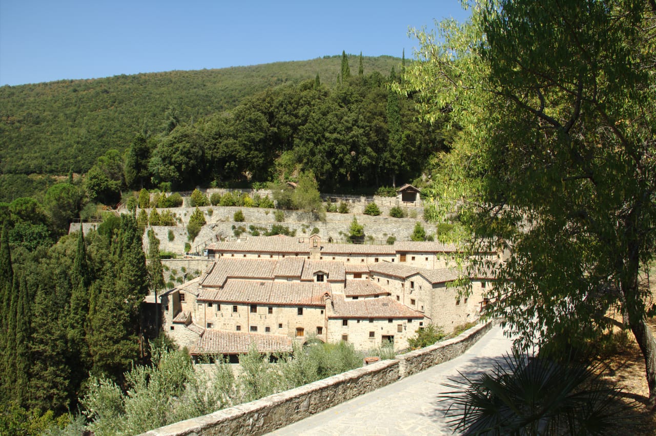 L'Eremo Le Celle incastonato nell'insenatura rocciosa del monte Sant'Egidio vicino a Cortona, tra cipressi e vegetazione