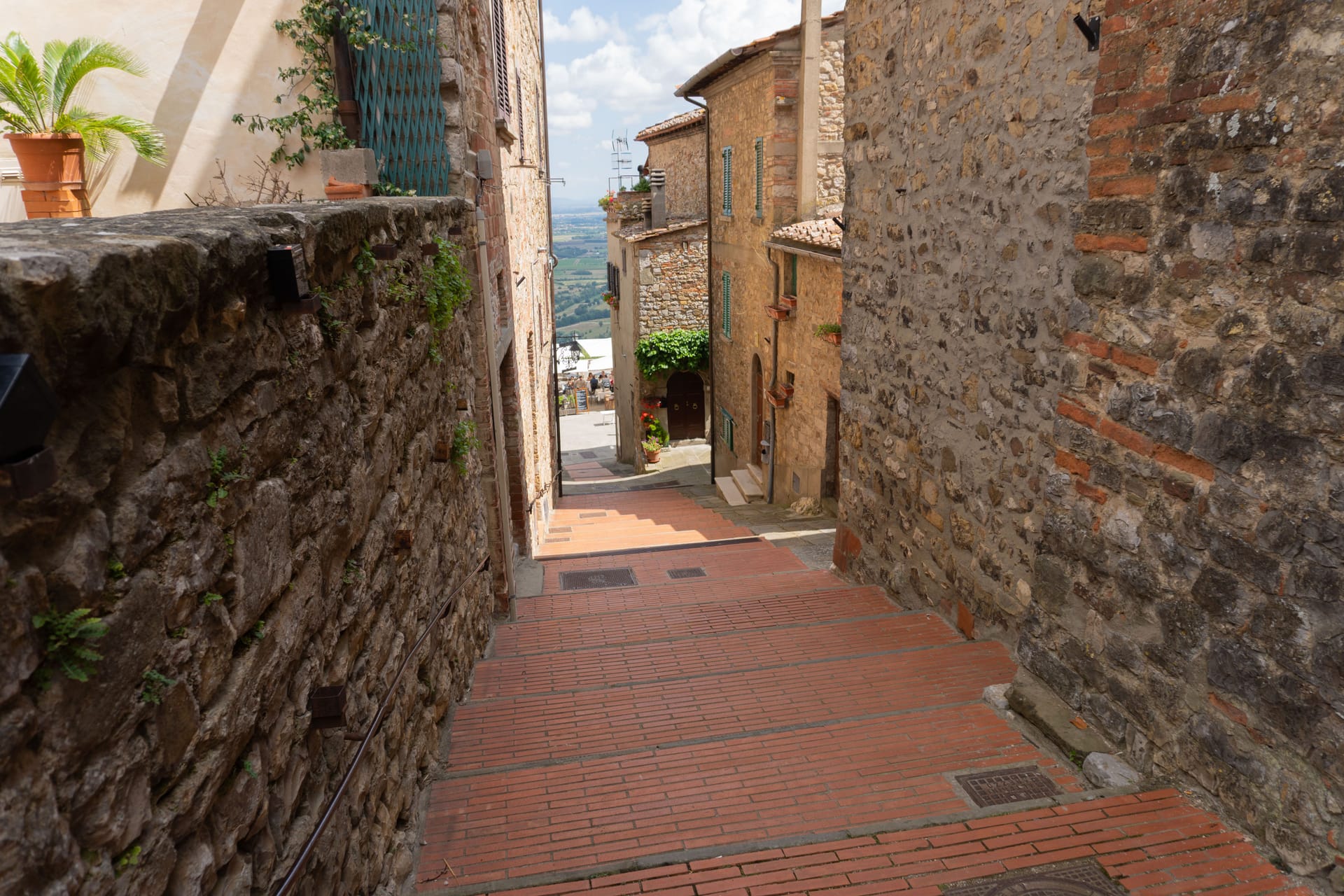 Stradina in salita del centro storico di Cortona nella luce calda del mattino, senza folla