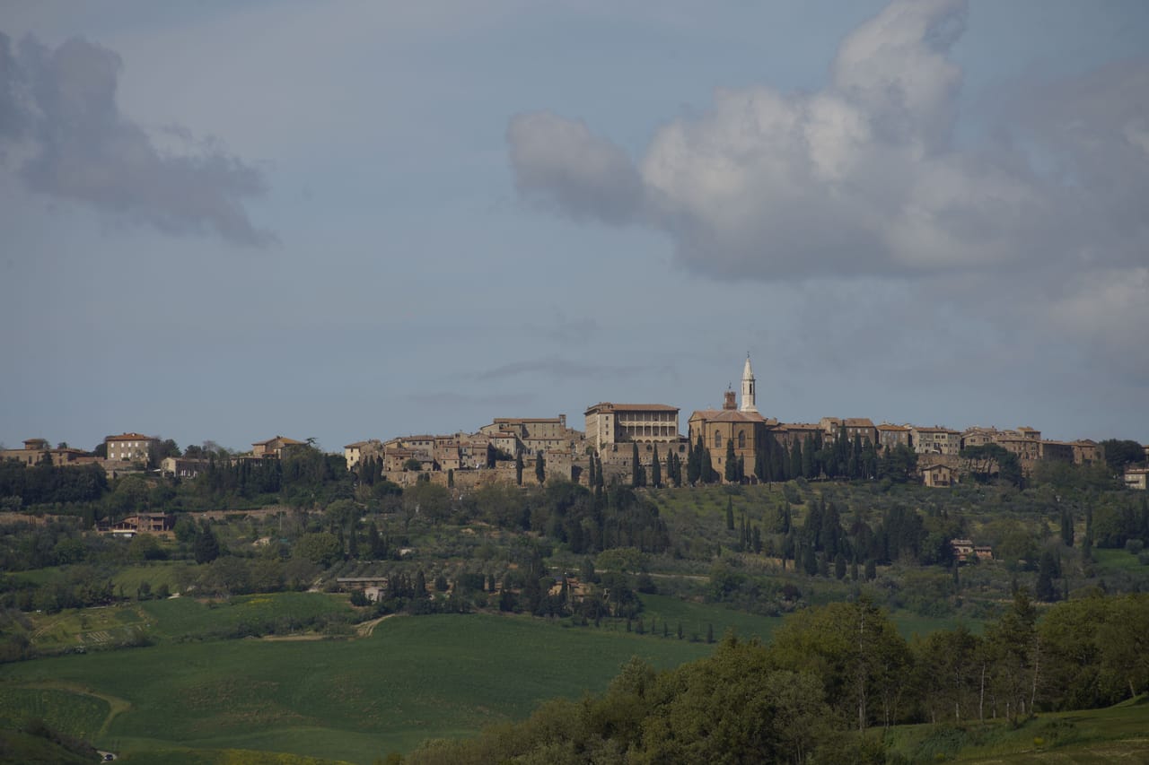 Panorama su Cortona e la Valdichiana al tramonto tra colline e cipressi