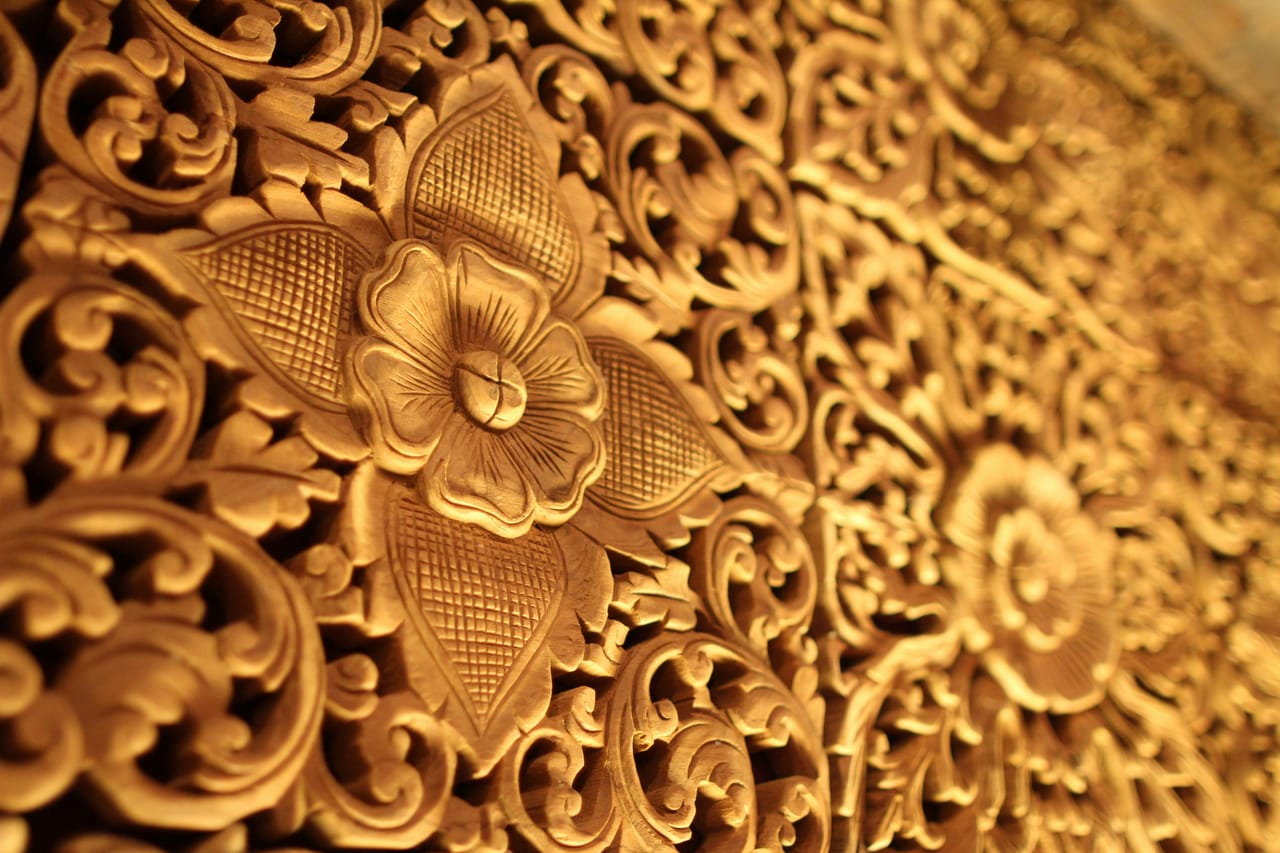 Carved and gilded wooden ceiling of a Renaissance church, with coffers and sculpted decorations seen from below.