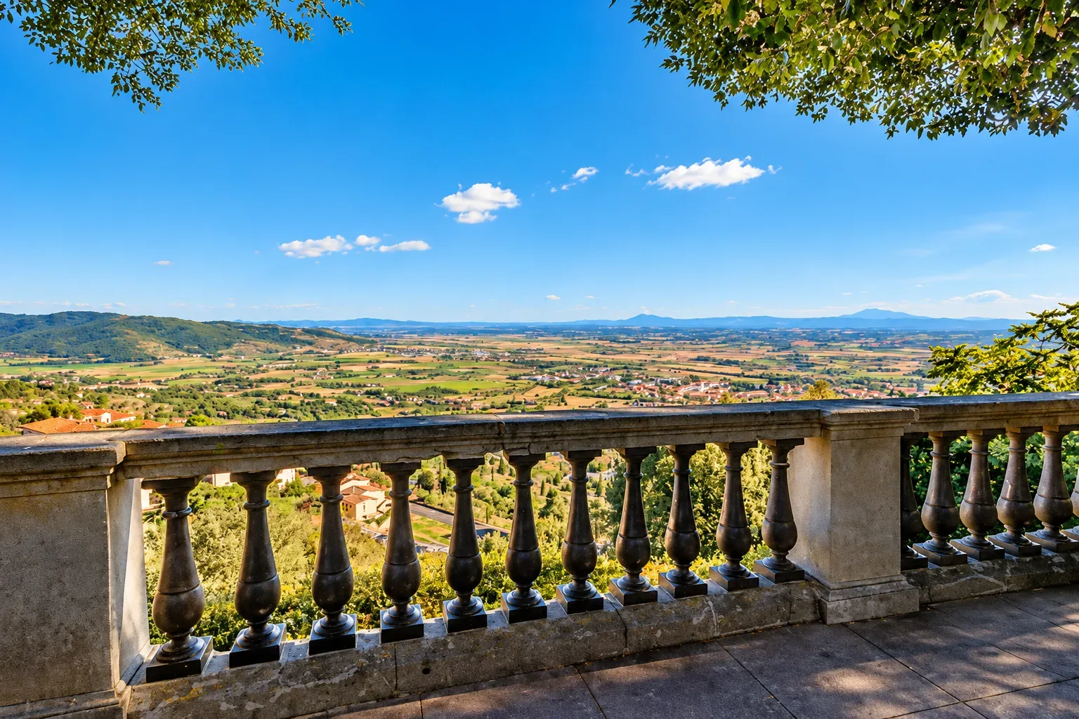 La campagna intorno a Cortona in primavera, con vigneti verdi e cielo variabile